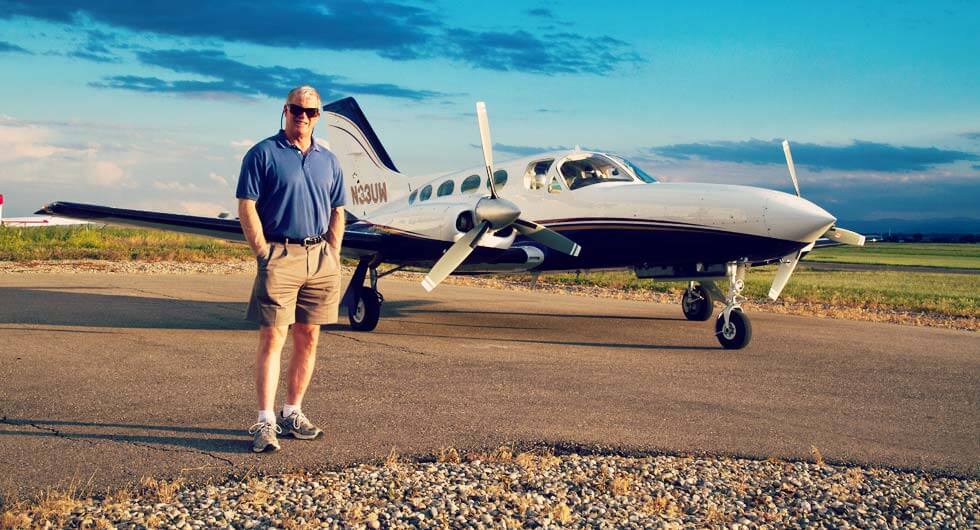 Dr. Stephen E. Brown standing near private Airplane